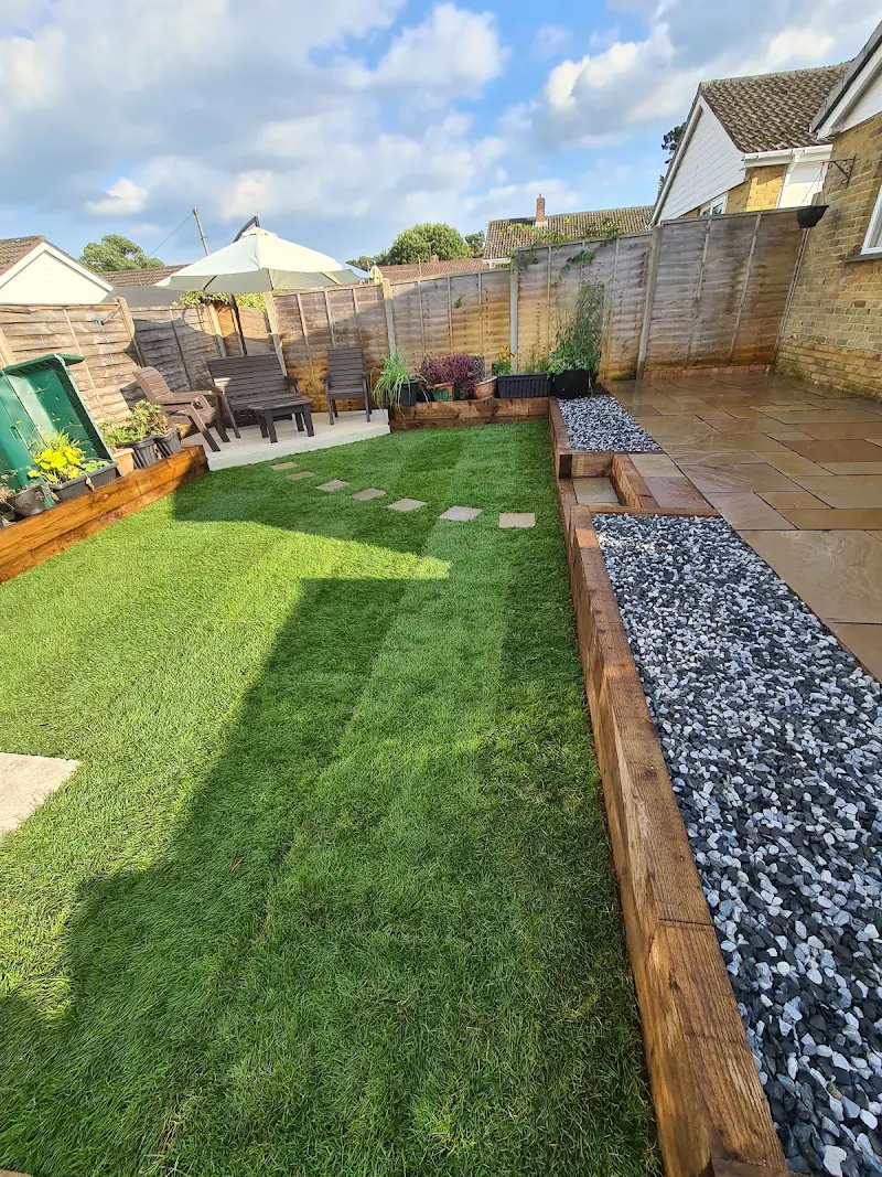Finished Southampton garden with new lawn, timber sleeper beds and a seating area, built by Quest Landscapes